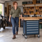 Woman pulling the rolling tool cabinet across the garage floor by its side handle